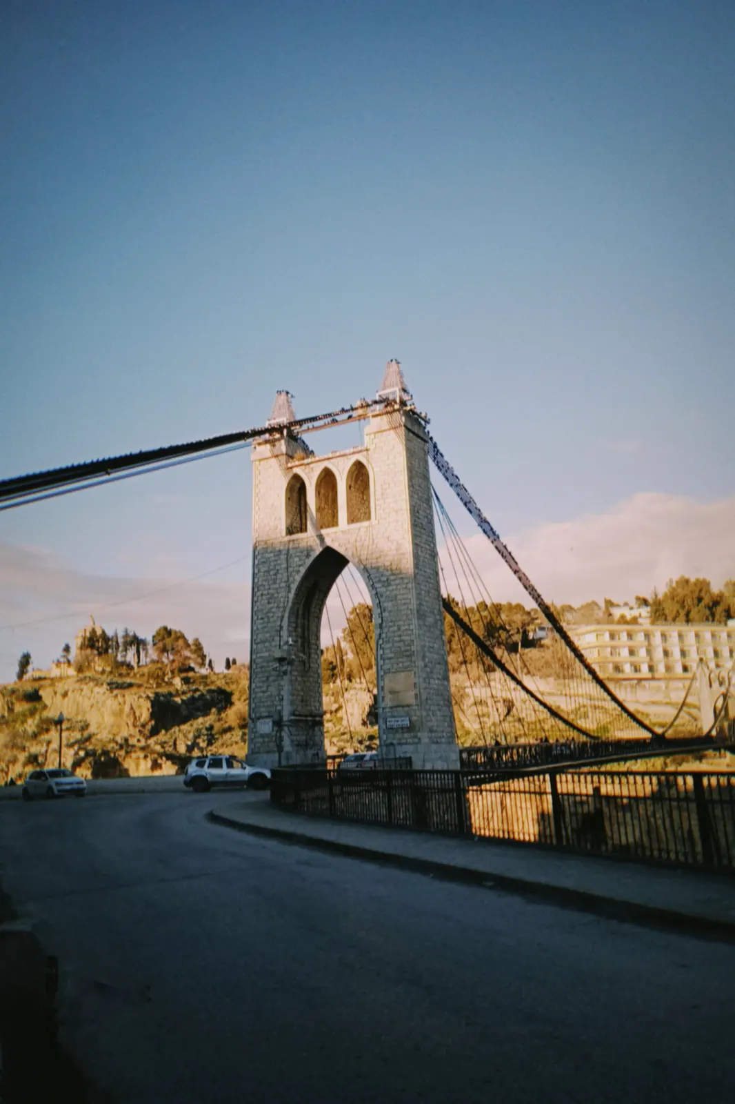 Stone tower of a suspension bridge in warm evening light